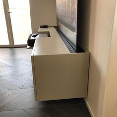 a flat screen tv mounted to the side of a wall next to a door way