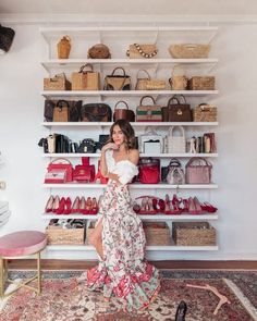 a woman standing in front of a closet full of purses and handbags on shelves