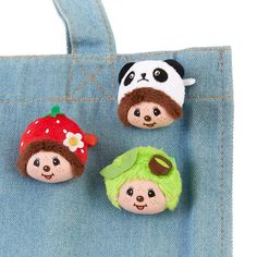 three small stuffed animals sitting on top of a denim bag