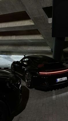 two black sports cars parked next to each other