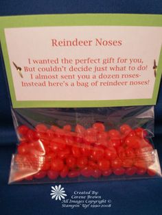 a bag filled with red candies sitting on top of a blue tablecloth next to a sign