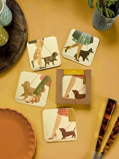 four coasters with dogs on them sitting on a table next to a plate and utensils