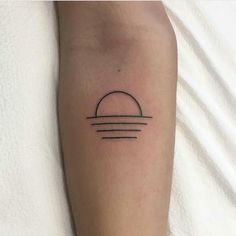 a person with a small tattoo on their arm that has the sun and clouds in it