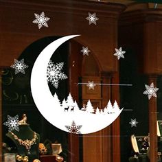 a window with snowflakes on it and a crescent moon in the middle, surrounded by christmas decorations