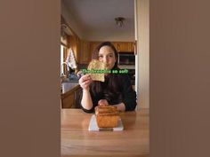 a woman sitting at a table with a piece of bread in front of her