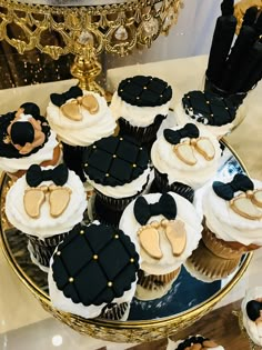 cupcakes with black and gold decorations on a plate