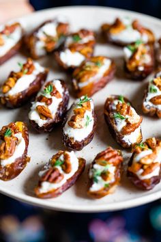 small appetizers on a plate being held by a person's hand in the foreground