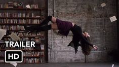 the magician's syfy is doing tricks in front of bookshelves