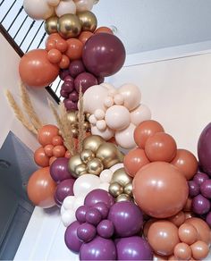 balloons are arranged in the shape of a triangle on top of each other, including gold and purple