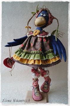 a colorful bird figurine is standing on top of a wooden block and wearing pink shoes