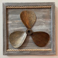 three guitar pickers mounted in a wooden frame