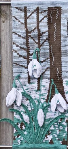 some white flowers are hanging on a wooden fence