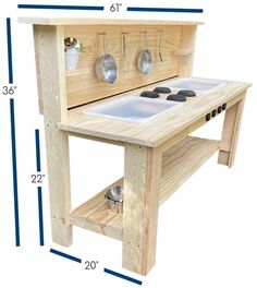 a wooden toy stove with two pots and pans on it's shelf, measurements