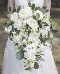 a bridal holding a bouquet of white flowers