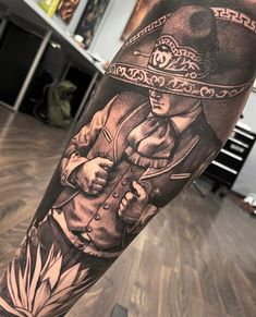 a man's arm with a black and grey tattoo on it, featuring an image of a woman wearing a hat