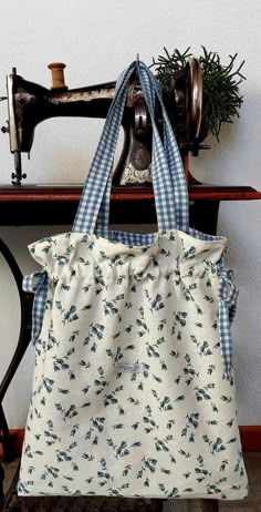 a white and blue bag sitting on top of a table next to a sewing machine