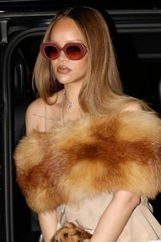 a woman wearing sunglasses and a fur stole