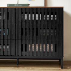 a black cabinet sitting on top of a hard wood floor