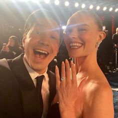 a man and woman posing for the camera at an event with their hands on each other's chest