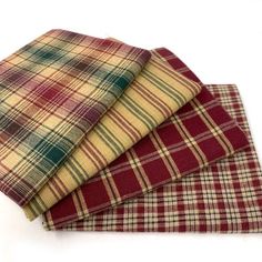 three pieces of plaid fabric folded on top of each other, one in red and the other in yellow