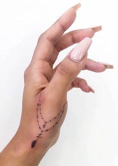 a woman's hand with a small tattoo on it