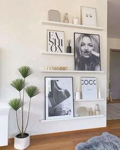 a living room filled with furniture and pictures on the wall next to a potted plant