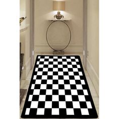 a black and white checkered area rug in a hallway with a lamp on the wall