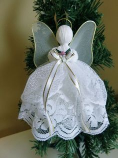 a white angel ornament hanging from a christmas tree