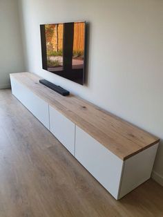 a flat screen tv sitting on top of a wooden shelf