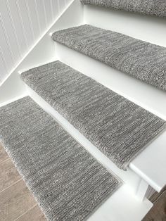 three rugs sitting on the floor next to each other in a room with white walls