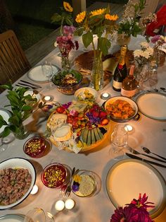 a table is set with plates, bowls and candles for a dinner party or celebration