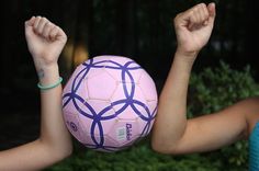 a person holding a pink soccer ball in their hands