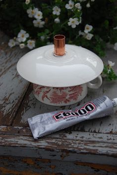 a tube of toothpaste sitting on top of a table next to a cup and saucer