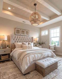 a large bed sitting in the middle of a bedroom under a chandelier above a window