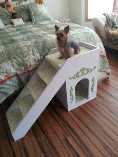 a small dog sitting on top of a pet house made to look like a castle