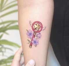 a person with a tattoo on their arm holding a magnifying glass and flowers