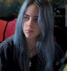 a woman with long grey hair sitting down