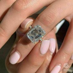 a woman's hand holding an engagement ring