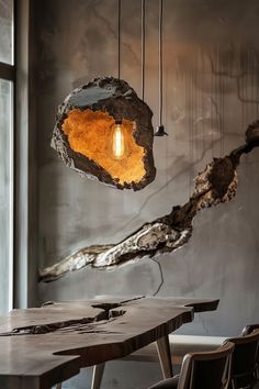 a wooden table sitting under a light hanging from it's centerpiece in front of a window