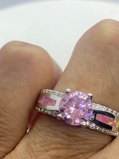 Unusual pale pink ice CZ and pink opal inlay. Deco sterling setting handmade Size 7 Can be resized. My jeweler charges $10-$20 All rings are shipped in a nice gift box. Check out our over a THOUSAND great reviews Engraving is $4 per letter and is not always perfect depending on the piece. It can take a few days if the jeweler is busy. This is payable to Paypal Judithsltd@gmail.com Pink Sterling Silver Rings With Accent Stones, Pink Round Stone Promise Ring, Pink Round Jewelry With Accent Stones, Pink Jewelry With Round Accent Stones, Pink Sterling Silver Jewelry With Center Stone, Sterling Silver Jewelry With Pink Center Stone, Pink Jewelry With Accent Stones, Pink Jewelry With Round Center Stone, Elegant Pink Opal Ring In Sterling Silver