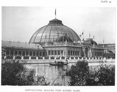 an old black and white photo of a building with a boat in the foreground