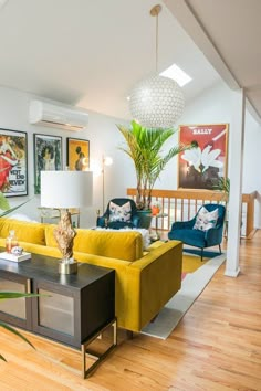 a living room filled with yellow couches next to a coffee table and lamp on top of a hard wood floor