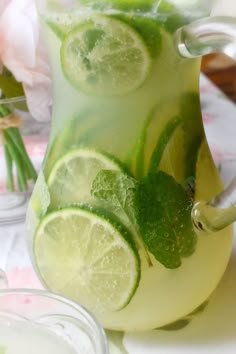 a pitcher filled with lemonade and lime slices