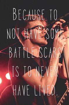 a man singing into a microphone with a quote on the side that says, because to not have some battle scars is to never have lived