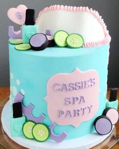 a blue cake with white frosting and pink icing on top that says cassile's spa party