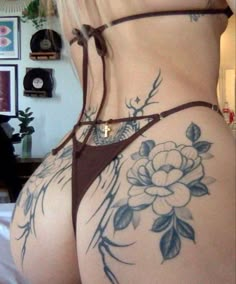 the back of a woman's body with tattoos and flowers on her butts