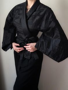 Sublime vintage kimono dating from the 1980s, a creation of the prestigious and confidential Parisian designer Christie de LaRue. It is made of 100% pure black silk of remarkable quality, very dense and solid with a beautiful shine in natural light. It is composed of a wild silk covered with patwork of silk strips, which gives a bold and theatrical look. The jacket is lined and has integrated ribbons to wrap around the waist at will. The cut is very poetic, giving a beautiful volume to the whole Silk Patchwork, Patchwork Kimono, Kimono Vintage, Black Goth, Pure Black, Pajama Robe, Vintage Kimono, Womens Robes, Black Silk