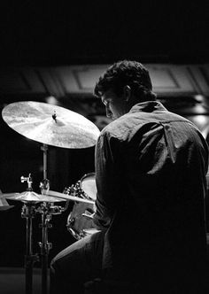 a man sitting in front of a drum set