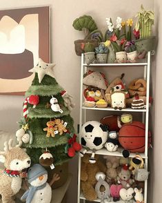 there is a christmas tree with stuffed animals on it next to a shelf filled with toys