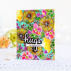 a card with flowers and the words hugs on it